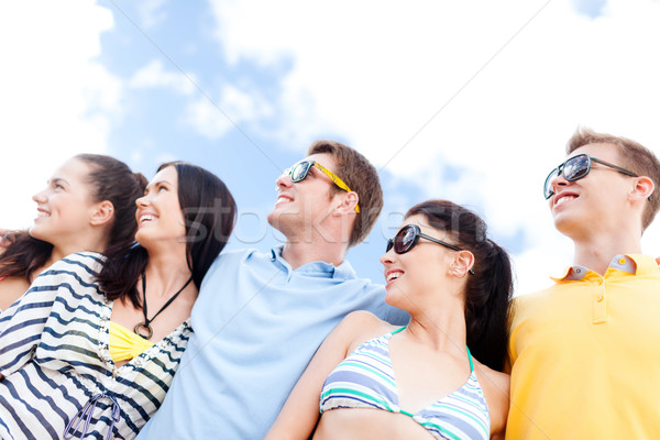 group of happy friends hugging on beach Stock photo © dolgachov