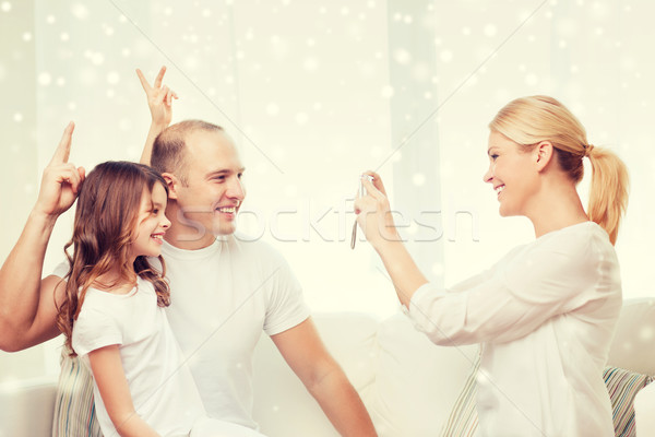 happy family with camera taking picture at home Stock photo © dolgachov
