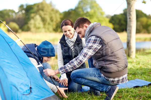 happy parents and son setting up tent outdoors Stock photo © dolgachov