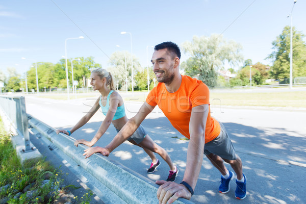close up of happy couple doing push-ups outdoors Stock photo © dolgachov