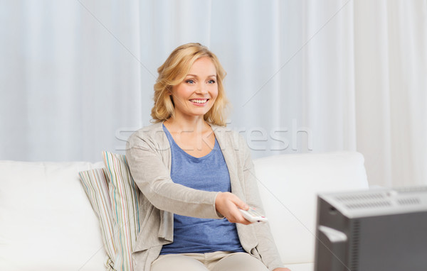 woman with remote control switching tv at home Stock photo © dolgachov