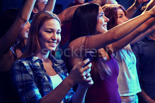 woman with smartphone texting message at concert Stock photo © dolgachov