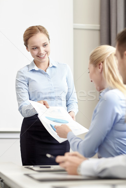 woman giving papers to group of businessmen Stock photo © dolgachov