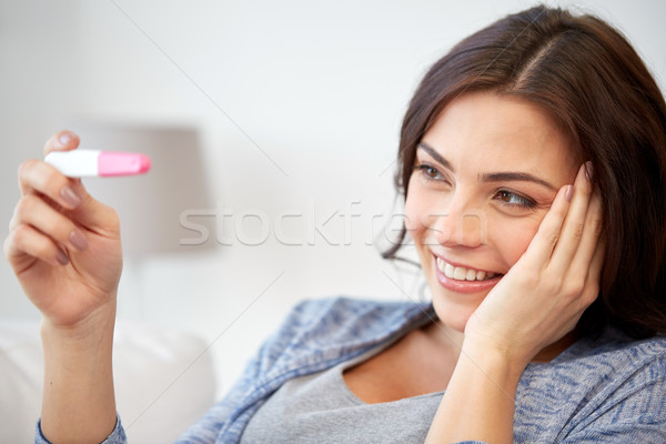 happy woman looking at home pregnancy test  Stock photo © dolgachov