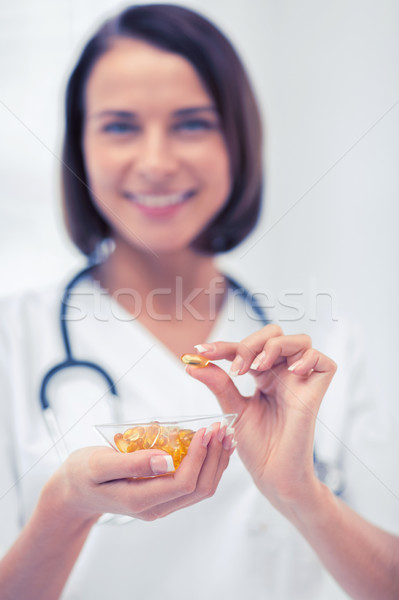 doctor holding bowl of capsules Stock photo © dolgachov
