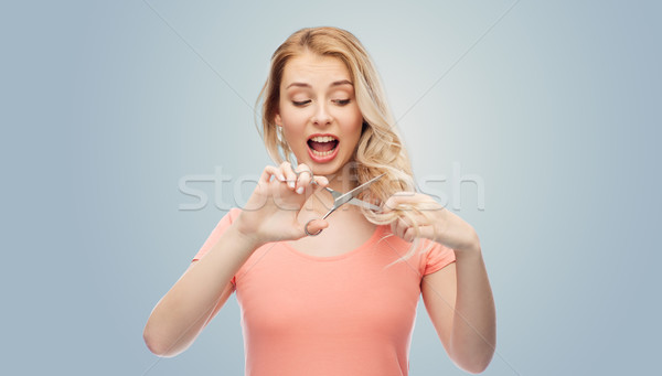woman with scissors cutting ends of her hair Stock photo © dolgachov