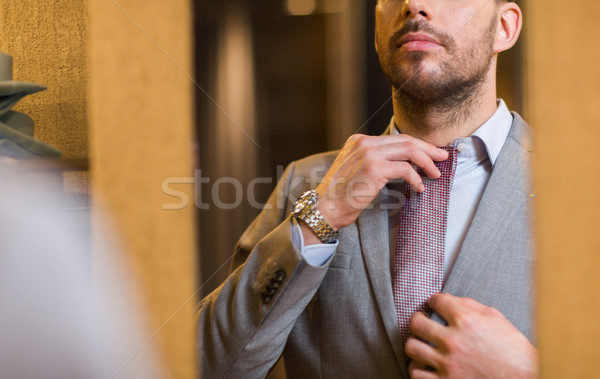 close up of man trying tie on at mirror Stock photo © dolgachov