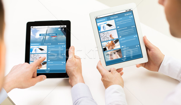 close up of hands with business news on tablet pc Stock photo © dolgachov