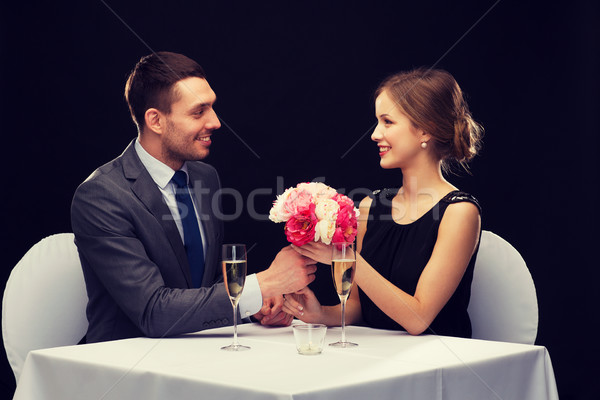 smiling man giving flower bouquet to woman Stock photo © dolgachov