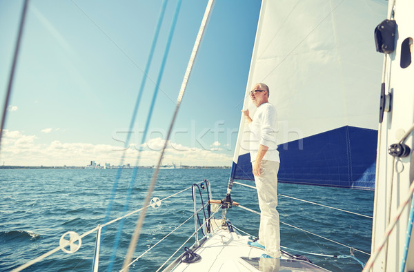senior man on sail boat or yacht sailing in sea Stock photo © dolgachov