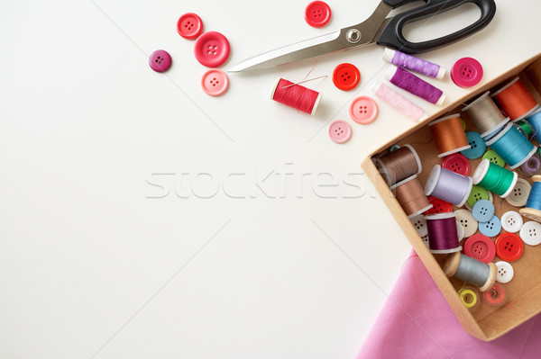 box with thread spools and sewing buttons on table Stock photo © dolgachov