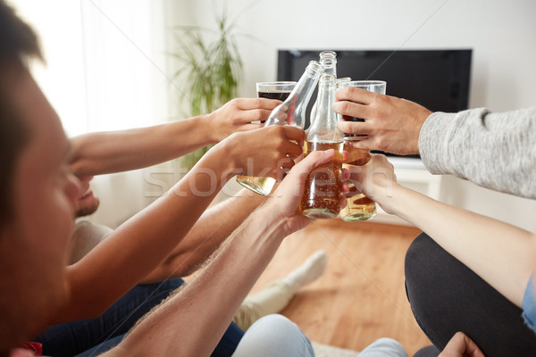 friends clinking beer and watching tv at home Stock photo © dolgachov