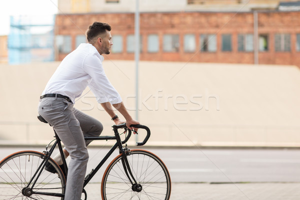 man with headphones riding bicycle on city street Stock photo © dolgachov