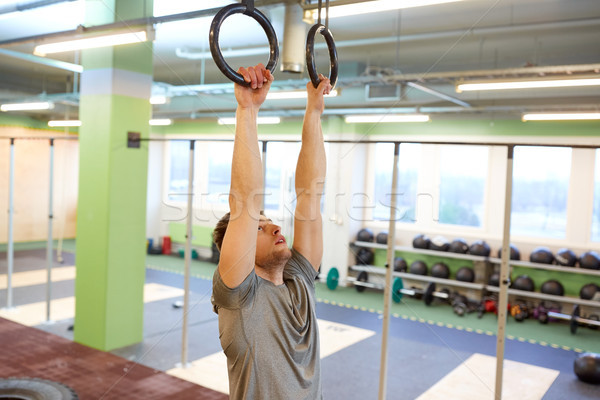 man exercising and doing ring pull-ups in gym Stock photo © dolgachov