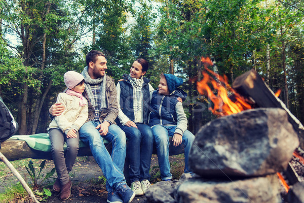Stock photo: happy family sitting on bench at camp fire