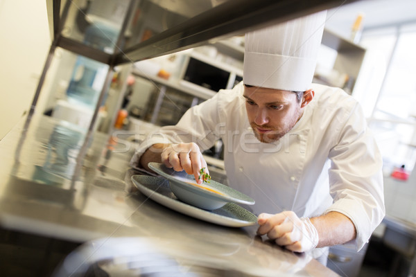 happy male chef cooking food at restaurant kitchen Stock photo © dolgachov