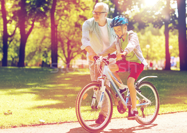 grandfather and boy with bicycle at summer park Stock photo © dolgachov
