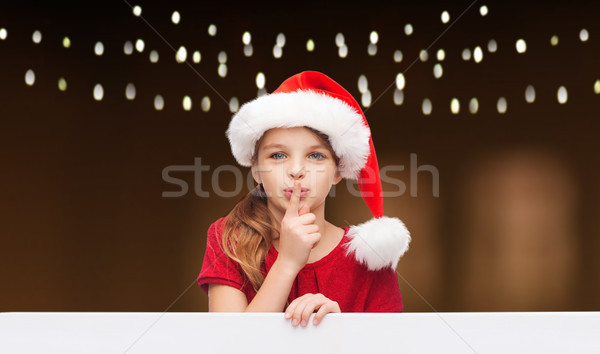 girl in santa hat with board making hush gesture  Stock photo © dolgachov