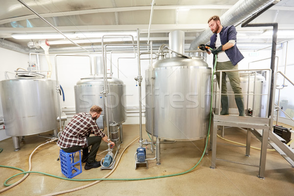 men working at craft beer brewery kettles Stock photo © dolgachov