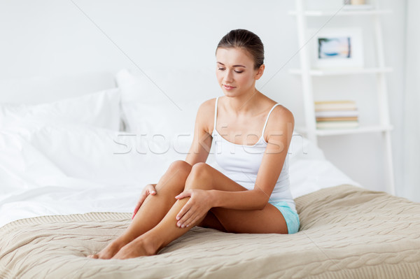 beautiful woman with bare legs on bed at home Stock photo © dolgachov