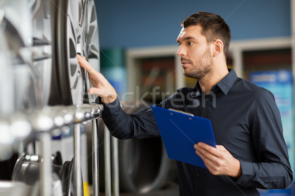 auto business owner and wheel rims at car service Stock photo © dolgachov