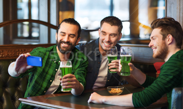 Stock photo: friends taking selfie with green beer at pub