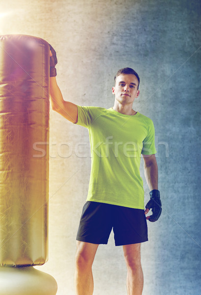 man with boxing gloves and punching bag in gym Stock photo © dolgachov