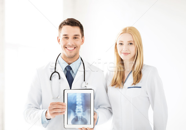 Stock photo: two doctors showing x-ray on tablet pc