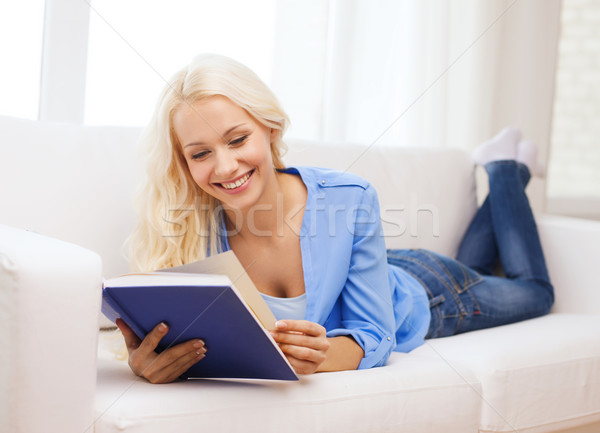 smiling woman reading book and lying on couch Stock photo © dolgachov