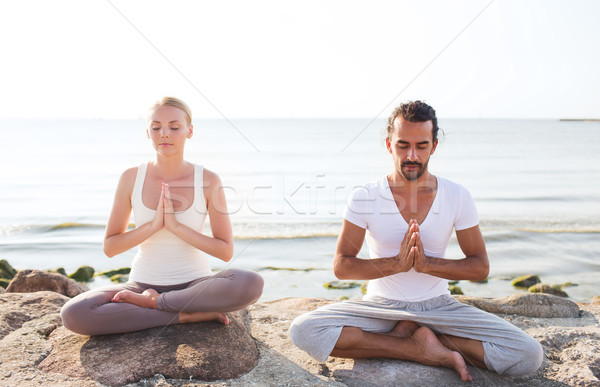 smiling couple making yoga exercises outdoors Stock photo © dolgachov
