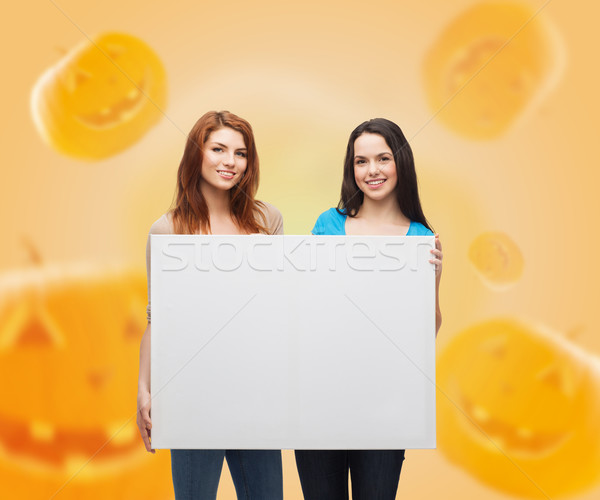 smiling teenage girls with white board Stock photo © dolgachov