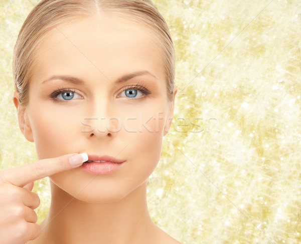 beautiful young woman pointing finger to her lips Stock photo © dolgachov