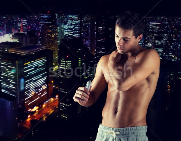 young male bodybuilder applying pain relief gel Stock photo © dolgachov