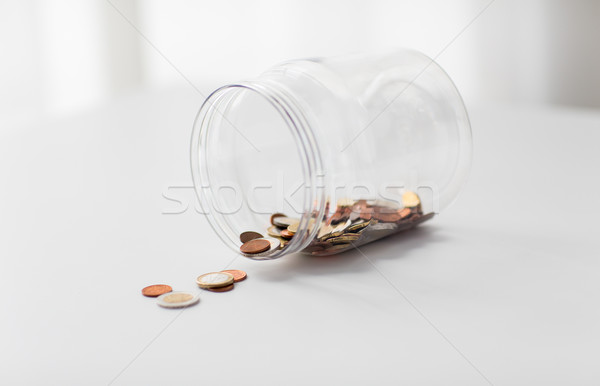 Stock photo: close up of euro coins in big glass jar on table