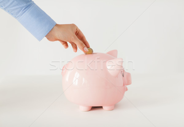 close up of hand putting coin to piggy bank Stock photo © dolgachov