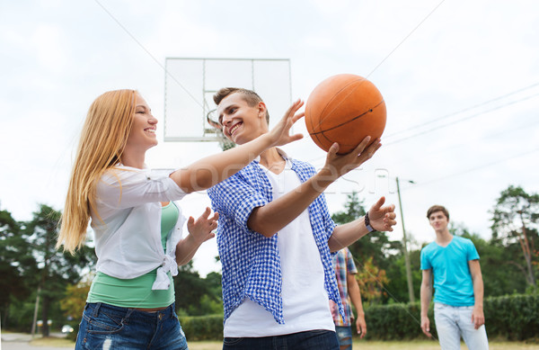 group of happy teenagers playing basketball Stock photo © dolgachov