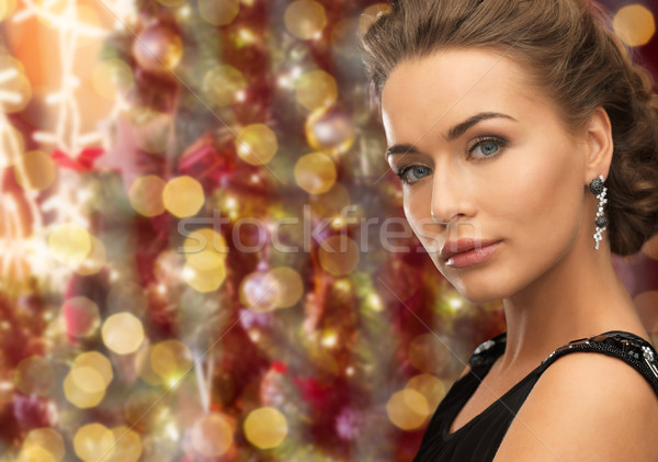 beautiful woman wearing earrings over lights Stock photo © dolgachov