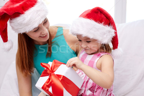 happy mother and child in santa hats with gift box Stock photo © dolgachov