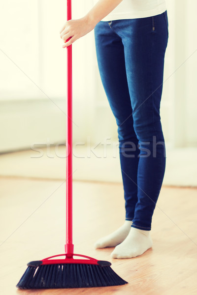 close up of woman legs with broom sweeping floor Stock photo © dolgachov