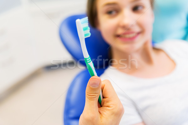 close up of dentist hand with toothbrush and girl Stock photo © dolgachov
