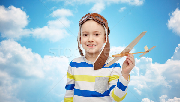 happy little boy in aviator hat with airplane Stock photo © dolgachov