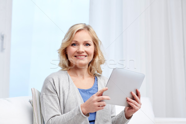 happy middle aged woman with tablet pc at home Stock photo © dolgachov