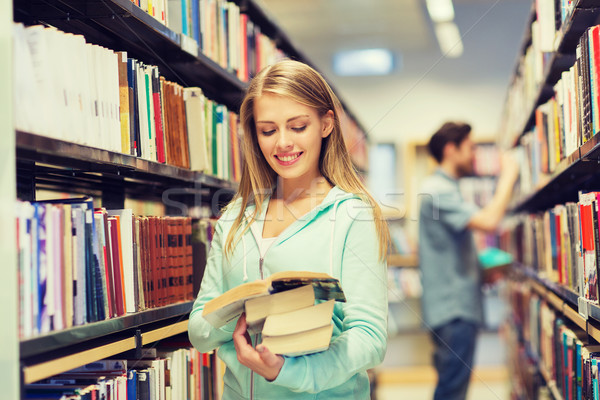 happy student girl or woman with book in library Stock photo © dolgachov