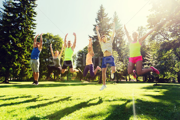 group of happy friends jumping high outdoors Stock photo © dolgachov