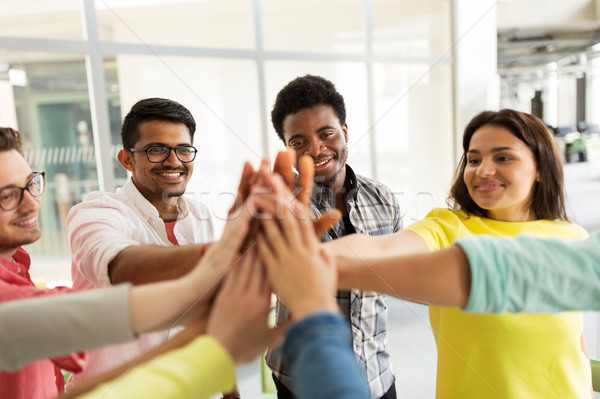 group of international students making high five Stock photo © dolgachov