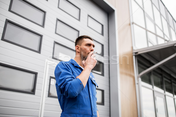 auto mechanic smoking cigarette at car workshop Stock photo © dolgachov