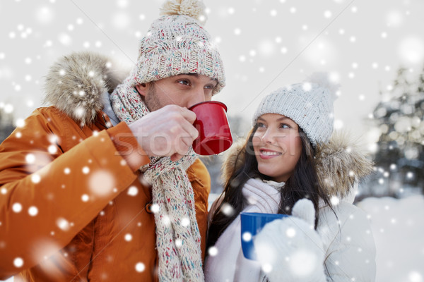 happy couple with tea cups over winter landscape Stock photo © dolgachov