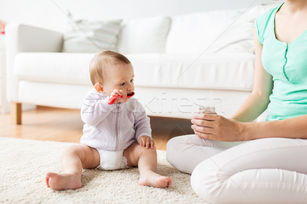 mother and baby with spoon eating puree at home Stock photo © dolgachov