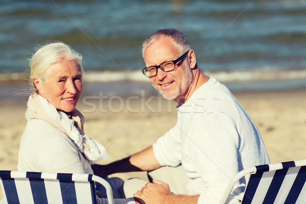 senior couple sitting on chairs at summer beach Stock photo © dolgachov