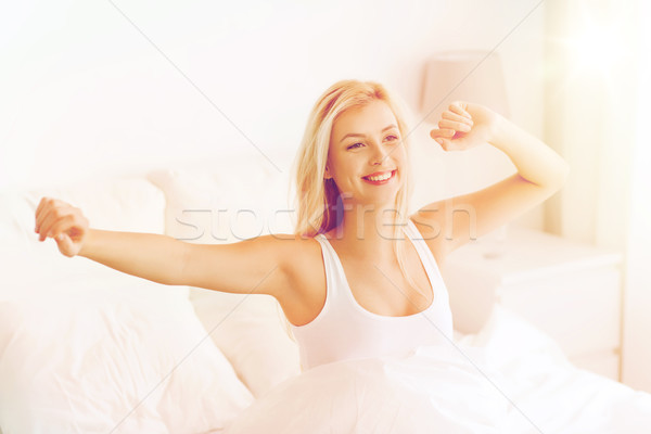 young woman stretching in bed after waking up Stock photo © dolgachov